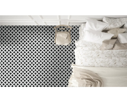 Vedere a unui dormitor cu gresie cu model geometric, un scaun și un pat