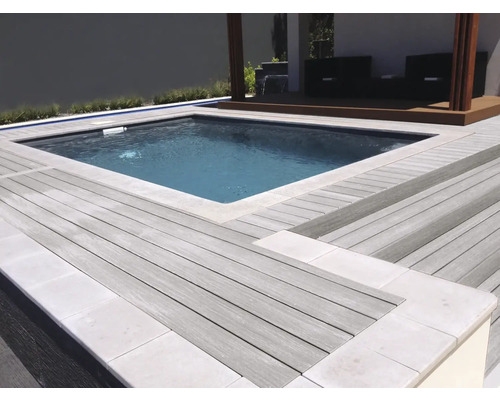 Piscină înconjurată de o terasă din lemn cu zonă de relaxare