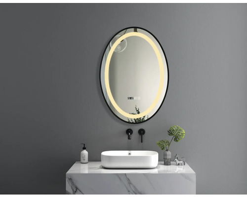 Scenă de baie cu o oglindă ovală cu iluminare LED deasupra unei chiuvete