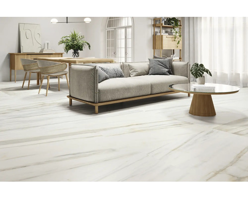 Cameră de zi luminoasă cu gresie cu aspect de marmură, canapea, masă și scaune.