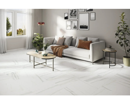 Cameră de zi luminoasă cu canapea albă, măsuță de cafea și podea albă cu aspect de marmură.