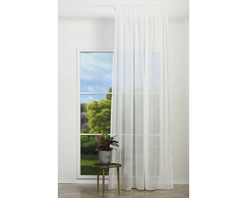 Fereastră cu perdea albă transparentă, plantă de apartament pe măsuță laterală
