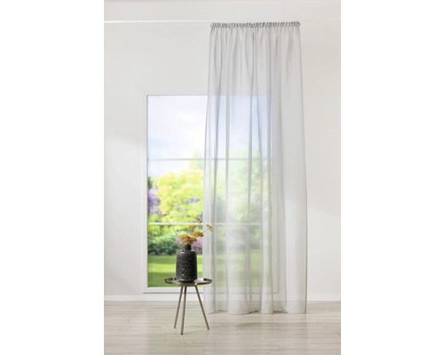 Cameră decorativă cu perdea transparentă, masă și vază.