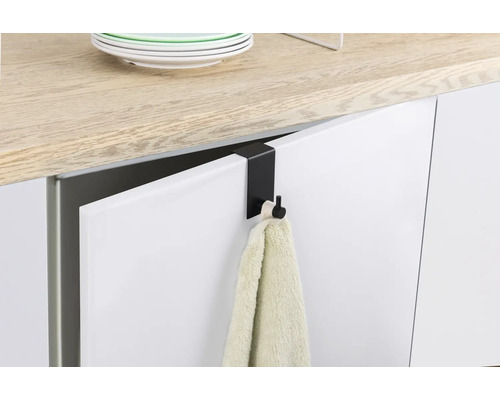 Cârlig negru pentru ușă cu prosop pe o ușă de bucătărie