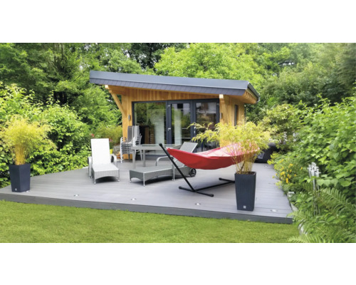 Căsuță de grădină cu terasă, mobilier de grădină și hamac în verdeață