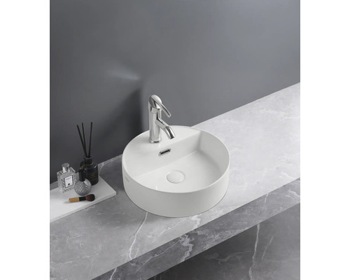 Lavabo rotund aplicat cu baterie pe un blat de lavoar