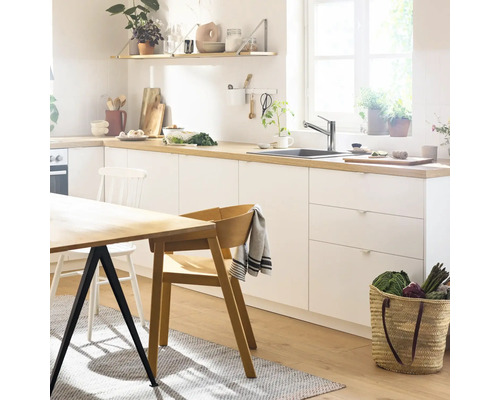 Bucătărie luminoasă cu masă, scaune și ustensile de bucătărie