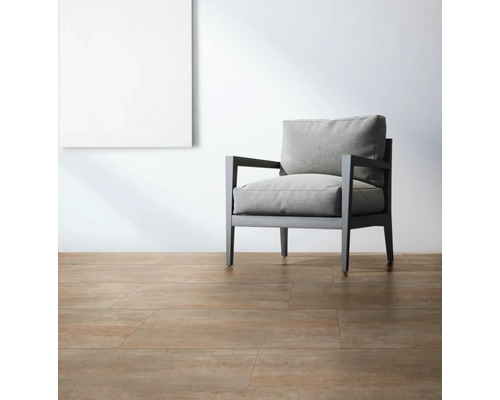 Cameră luminoasă cu gresie, fotoliu și un tablou pe perete