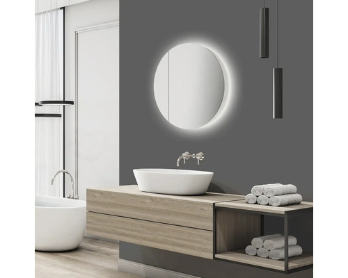 Baie modernă cu oglindă rotundă, lavoar așezat pe blat și dulap inferior din lemn