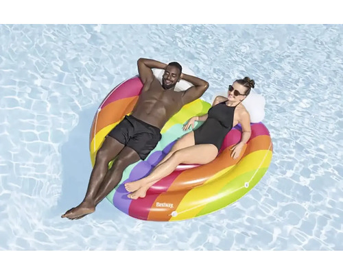 Două persoane se relaxează pe o insulă gonflabilă colorată în piscină.