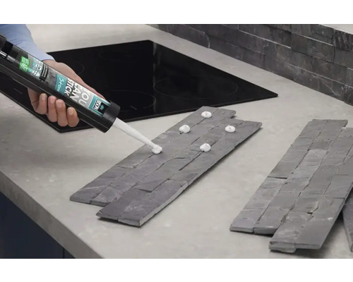 Aplicarea adezivului de montaj pe panourile de piatră pentru montarea pe perete.