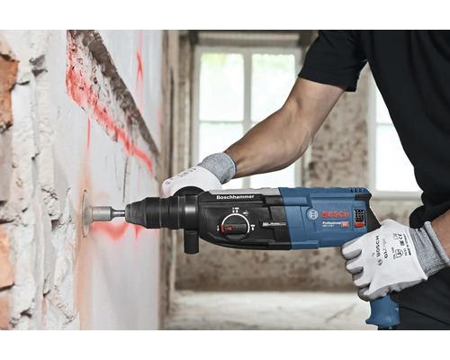 Artizan care găurește un perete cu un ciocan rotopercutor