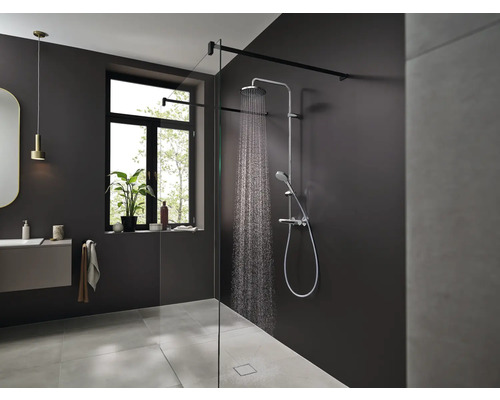 Baie modernă cu duș, chiuvetă și fereastră pentru o ambianță luminoasă și prietenoasă.