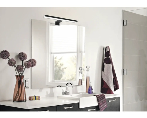 Baie modernă cu chiuvetă, oglindă, lampă și decorațiuni.