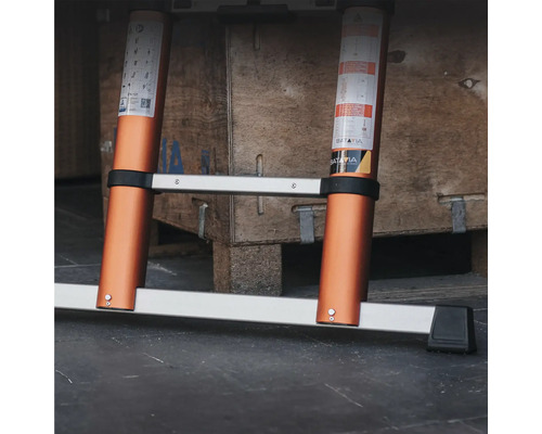 Scară din aluminiu extinsă în fața unei cutii din lemn