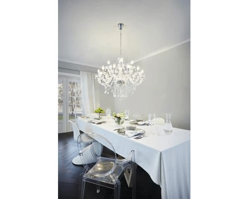 Masa de sufragerie cu veselă și candelabru de cristal într-o cameră luminoasă