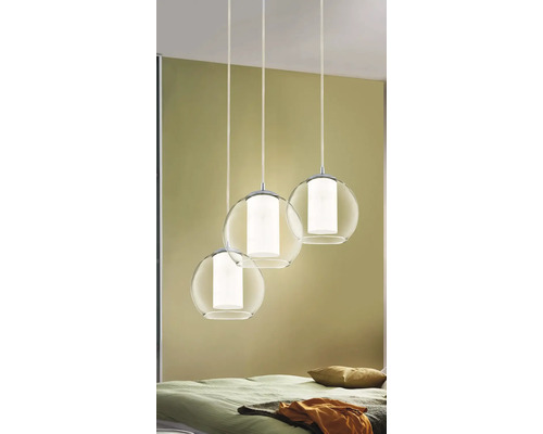 Trei lămpi sferice din sticlă transparentă atârnă de tavan.