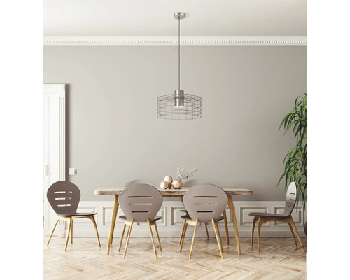 Sufragerie cu masă din lemn, scaune și o lampă suspendată cu abajur din sârmă.