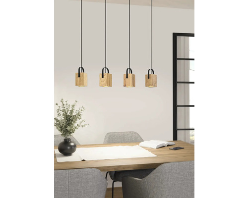 Lampa suspendată cu patru abajururi din lemn deasupra unei mese de sufragerie