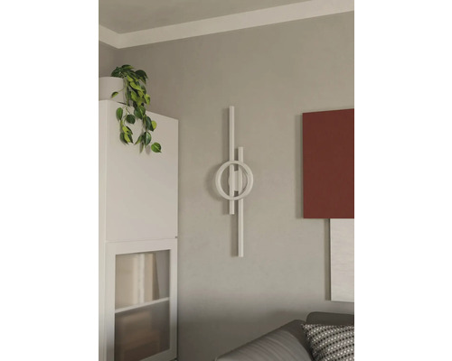 Cameră de zi cu lampă de perete decorativă și plantă de interior pe un dulap alb