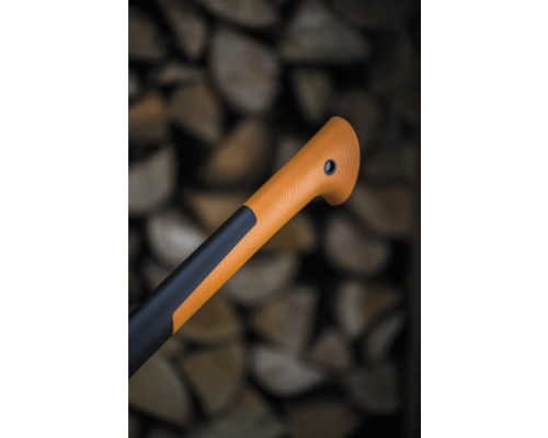 Detaliu cu mânerul unui topor pe fundalul unei grămezi de lemn