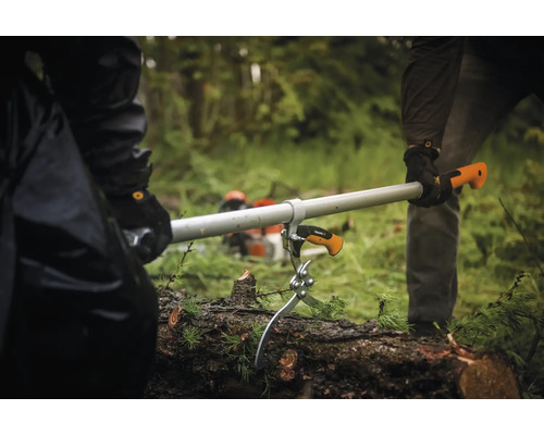 Două persoane folosesc un levier pentru arbori pentru a muta un trunchi de copac.