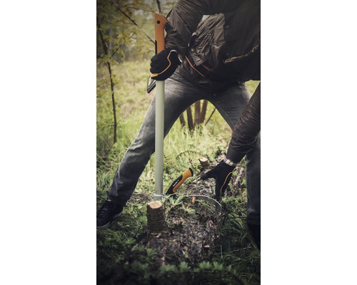 O persoană folosește un topor de despicat și un cârlig de lemn pentru a tăia lemne afară.