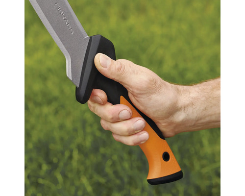 Prim-plan cu o mână care ține o macetă Fiskars cu mâner portocaliu