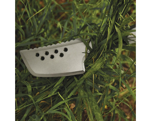 Prim-plan cu un cuțit de supraviețuire cu găuri și o lamă zimțată în iarbă