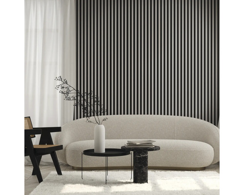 Living cu canapea, scaun și decorațiuni în fața unui perete cu dungi verticale