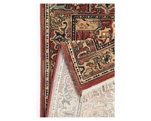 Detaliu al unui covor roșu cu design modelat și franjuri