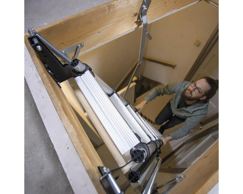 Un bărbat coboară pe o scară de pod