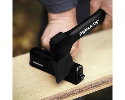 Logo Fiskars pe ascuțitor de topoare în uz pe o scândură de lemn