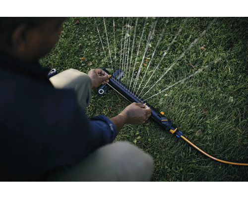 Aspersor de grădină în acțiune, udând gazonul