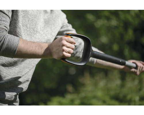 O persoană ține în mână un dispozitiv de scos buruieni cu mâner.