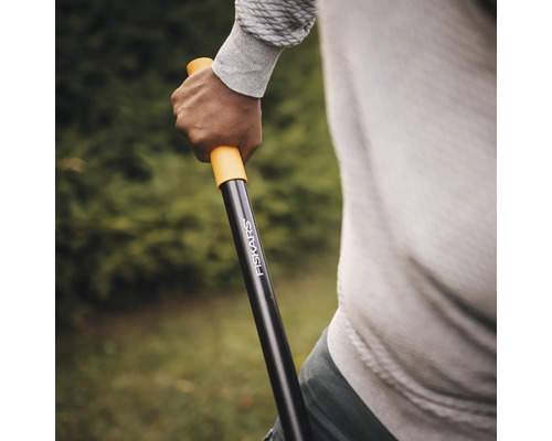 Persoană care ține unealtă de grădinărit Fiskars în mână