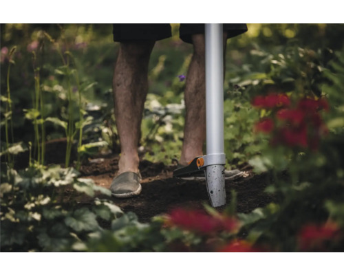 Grădinar folosind un plantator în grădină.