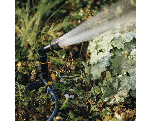 Aspersor de grădină udând plante în grădină