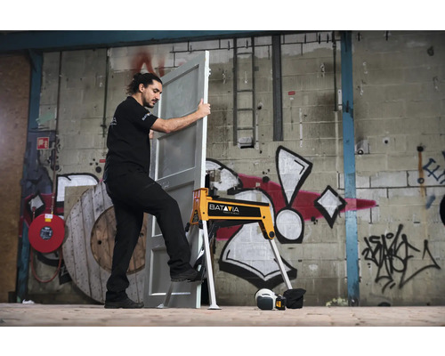 Un bărbat poziționează ușa cu cricul de ușă de la Batavia