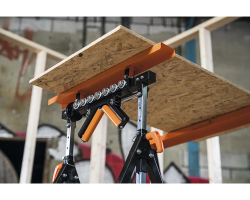 Doi capre susțin o placă OSB într-un atelier