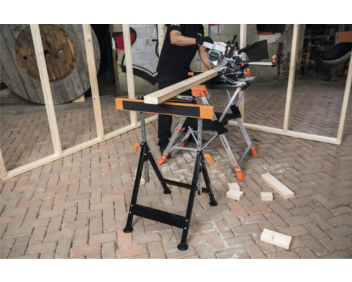 Scenă cu o persoană tăind o scândură de lemn pe un banc de lucru cu un ferăstrău circular.