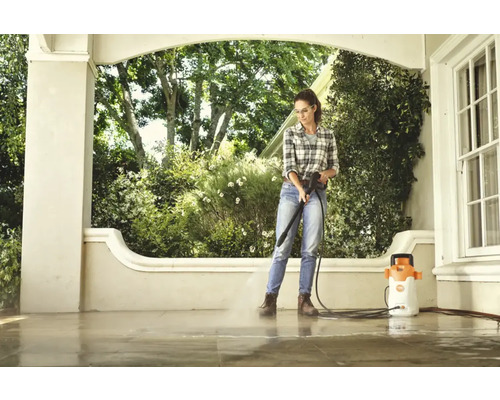 Femeie curăță terasa cu un aparat de curățat cu presiune