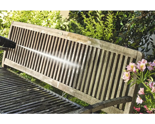 Curățarea unei bănci de grădină din lemn cu un curățător cu presiune înaltă.