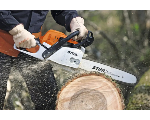 Persoană taie un trunchi de copac cu un ferăstrău cu lanț Stihl