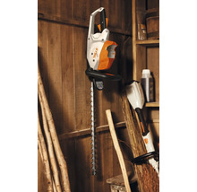 Foarfecă de gard viu fără fir Stihl pe un perete de lemn.