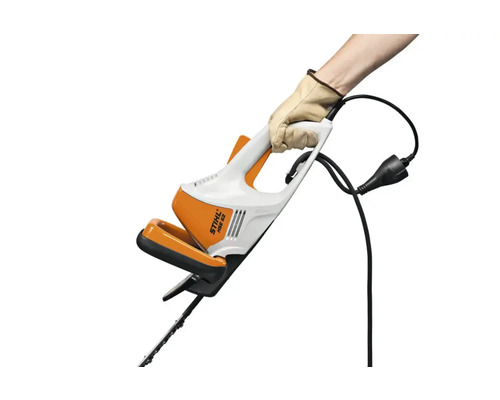 Foarfecă electrică pentru gard viu STIHL HSE 52 în mână cu mănușă de protecție