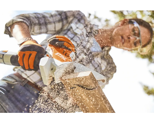 O persoană taie o scândură de lemn cu un ferăstrău Stihl.