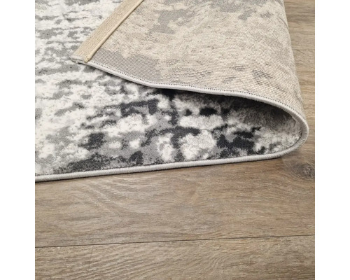 Covor cu model abstract pe podea de lemn