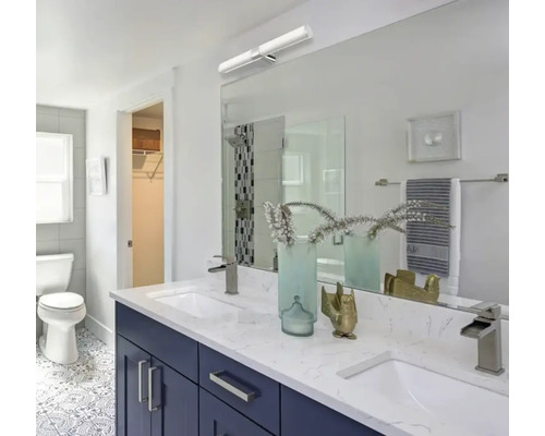 Baie modernă cu chiuvetă dublă, oglindă și iluminare.