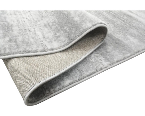 Imagine detaliată a unui covor gri cu model amestecat și margini festonate